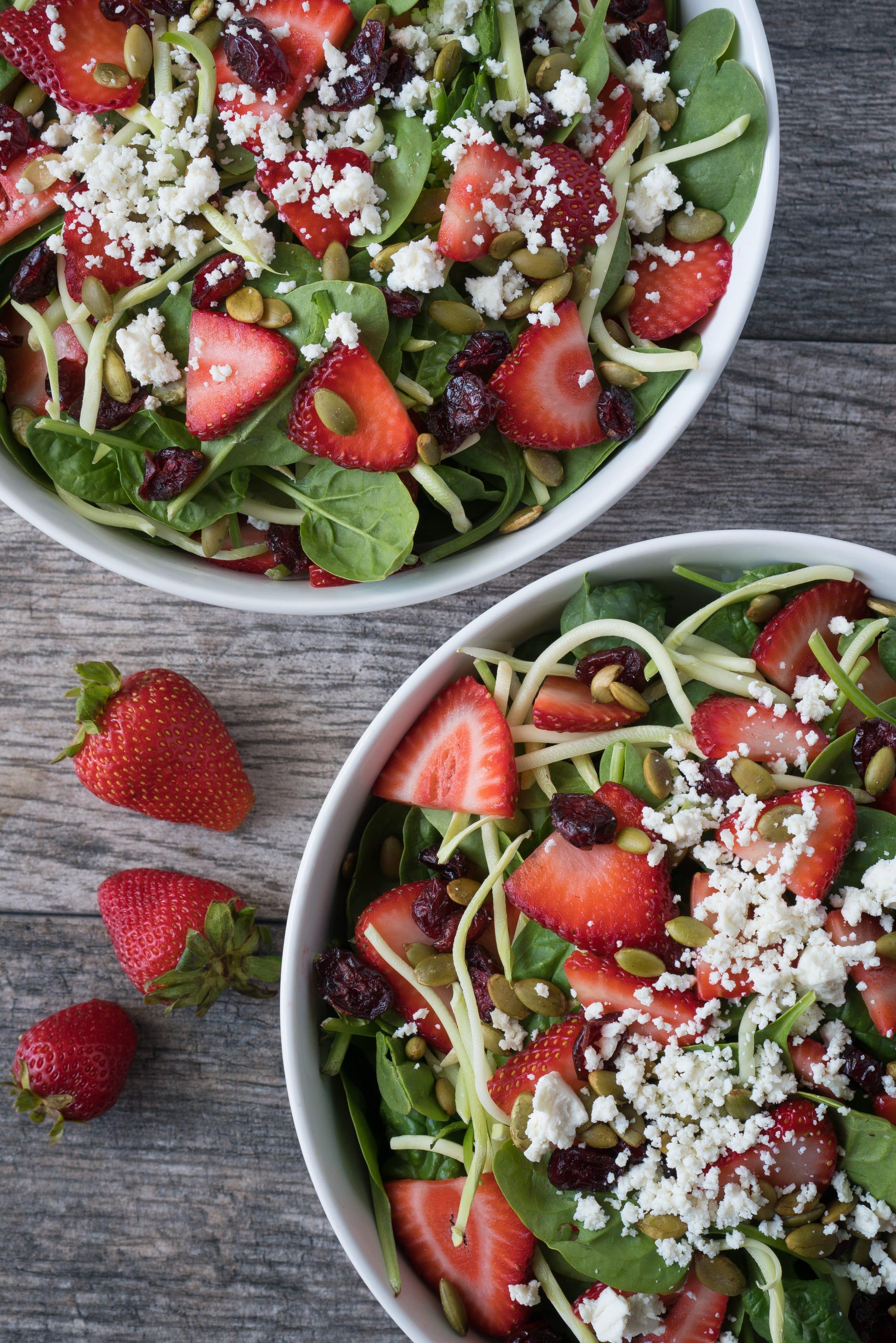 Strawberry Pepita Salad – Healthy recipe for a Strawberry Pepita Salad, with a tangy homemade Maple Vinaigrette. Using baby spinach and broccoli slaw topped with honey goat cheese crumbles, toasted pepitas, fresh sliced strawberries, and sweet dried cranberries. All ready in under 15 minutes! ♥ | freeyourfork.com