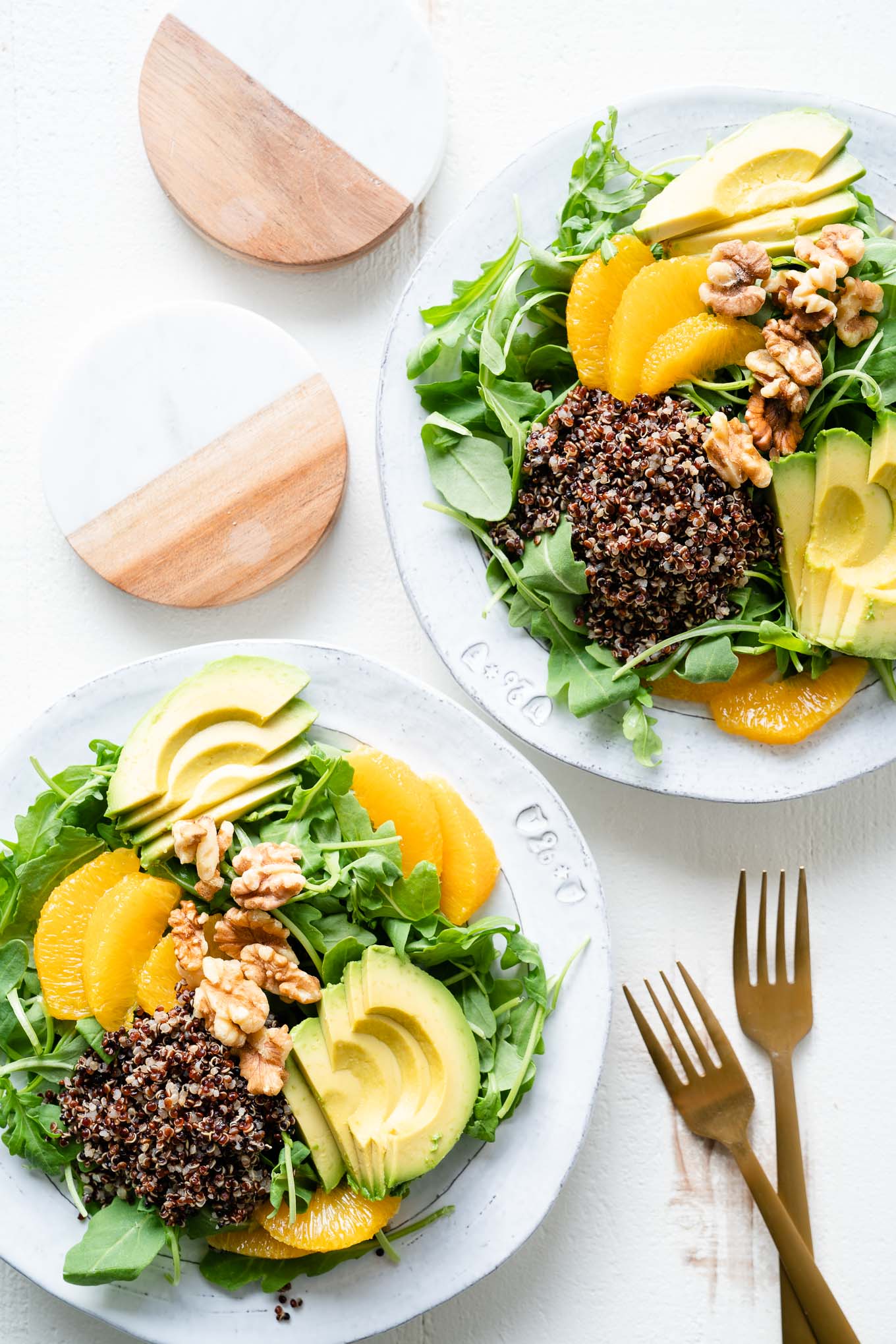 Plated avocado quinoa power salads with gold forks
